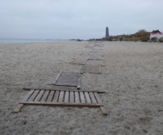 16 am Strand liegen die letzten Sandschutzbretter bereit